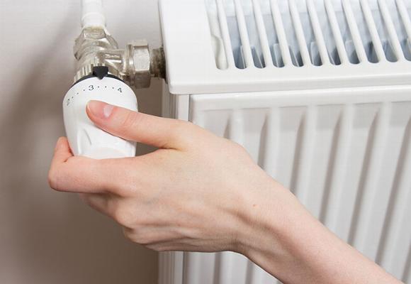 hand adjusting radiator thermostat